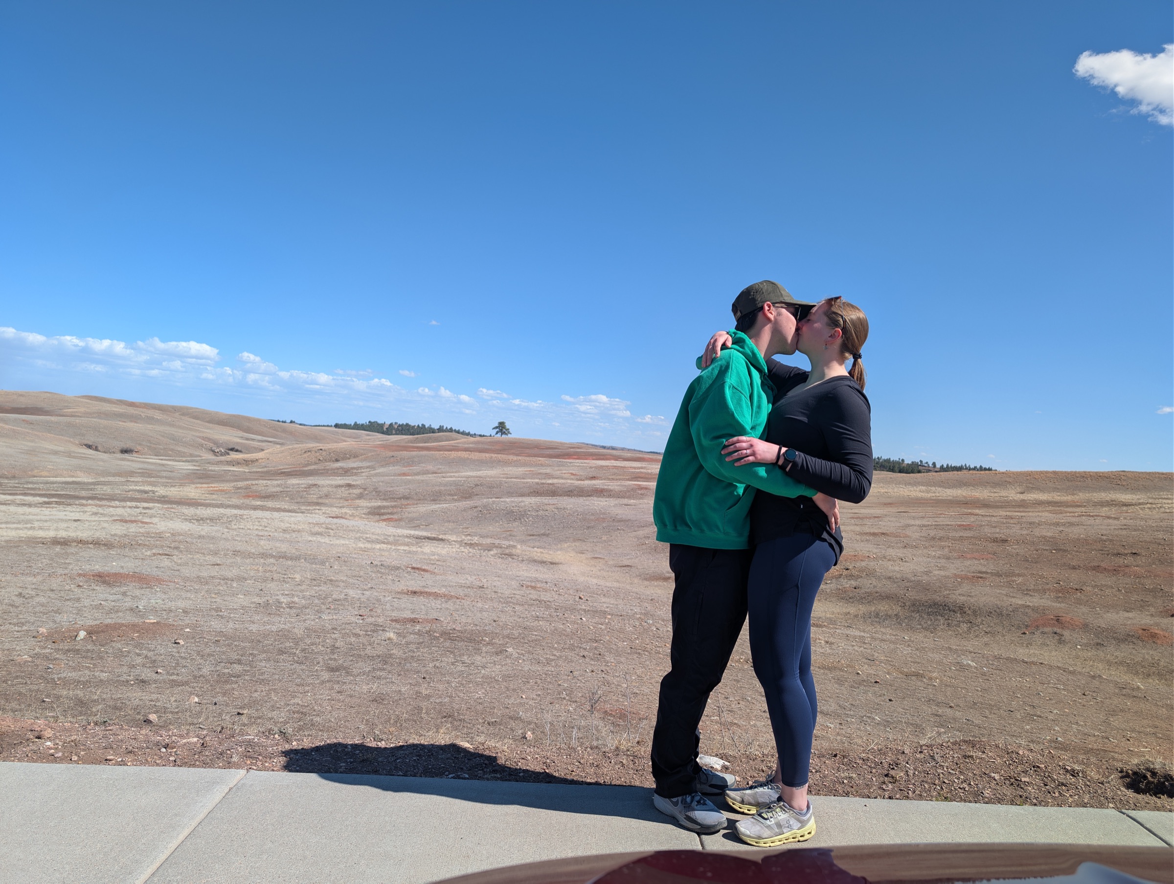 Jenny and Tanner sharing a kiss in the rolling hills